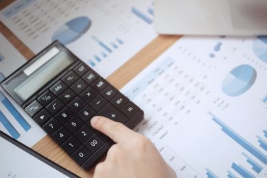 a calculator lying on a desk full of papers